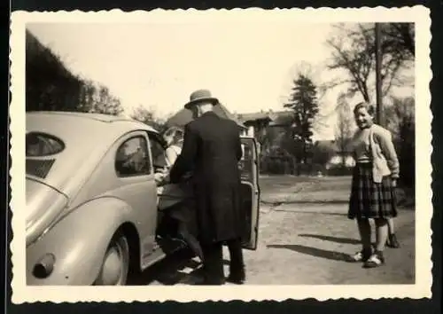 Fotografie Auto VW Käfer, Grossvater schiebt seinen Enkel in das Auto