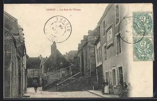 AK Donzy, La Rue de l`Étape avec bâtiments et passants