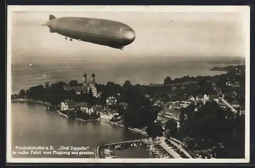 AK Friedrichshafen /Bodensee, Graf Zeppelin in Fahrt über die Ortschaft, Ansicht vom Flugzeug aus