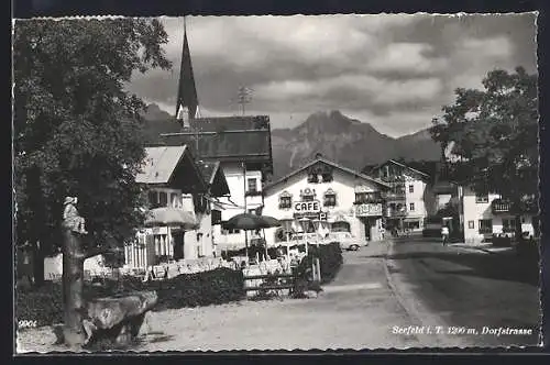 AK Seefeld i. T., Dorfstrasse mit Trinkbrunnen, Café und Bergpanorama