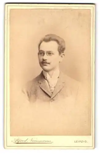 Fotografie Alfred Naumann, Leipzig, junger Mann im Anzug mit Brille, 1890