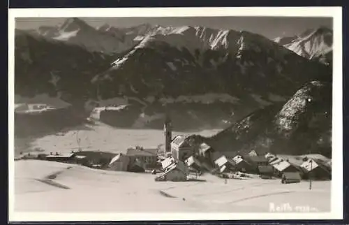 AK Reith, Verschneite Ortsansicht mit Bergpanorama