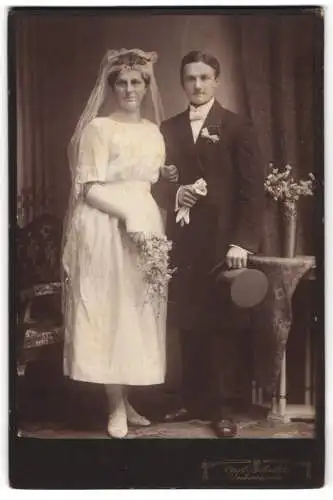Fotografie Carl Schultz, Ueckermünde, Eheleute am Hochzeitstag im Brautkleid und Anzug mit Zylinder