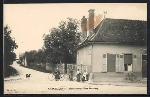 AK Creney, Établissement Mme Sansonay avec cyclistes et chien sur la route