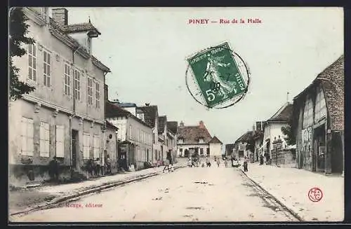 AK Piney, Rue de la Halle animée avec bâtiments anciens et passants