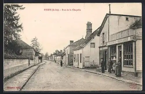 AK Piney, Rue de la Chapelle avec magasin de mercerie et passants