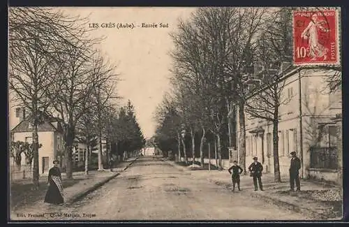AK Les Grès, Entrée sud avec arbres et passants sur la route principale