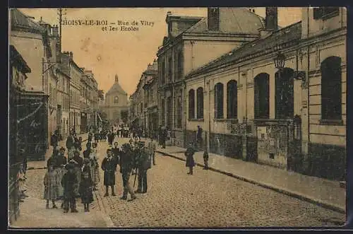 AK Choisy-le-Roi, Rue de Vitry et les Écoles avec des passants sur la rue pavée