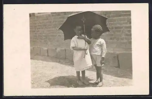 AK Afrikanisches Kinderpaar unter einem Schirm, afrikanische Volkstypen