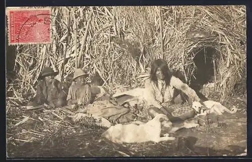 AK Drei Indios mit zwei Hunden vor einer Basthütte in der Sonne