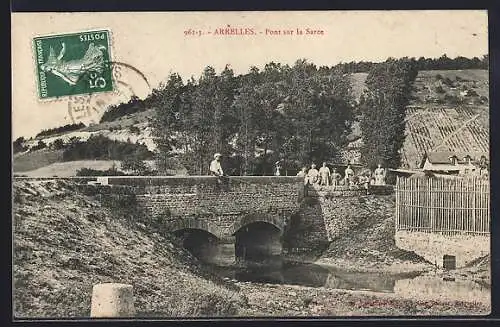 AK Arrelles, Pont sur la Sarce avec des passants sur le pont et paysage rural en arrière-plan