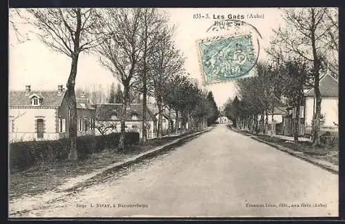 AK Les Grès, Rue bordée d`arbres et maisons en rangée