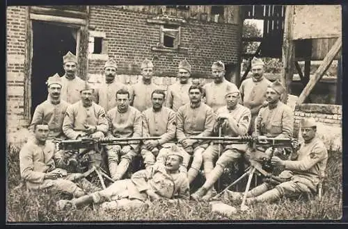Foto-AK Soldatengruppe mit Infanteriegeschütz vor einem Stallgebäude