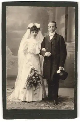 Fotografie unbekannter Fotograf und Ort, Hochzeitspaar posiert im Brautkleid mit Schleier und im Anzug mit Zylinder