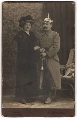 Fotografie P. Sage, Treuenbrietzen, Soldat Adolf in Uniform mit Pickelhaube und Säbel nebst seiner Frau
