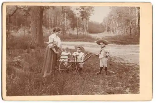 Fotografie unbekannter Fotograf und Ort, Mutter mit ihren drei Kindern im Wald, Kinderwagen