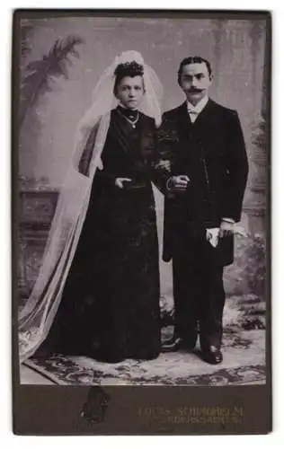 Fotografie Louis Schindhelm, Ebersbach i. Sa., Ehepaar am Hochzeitstag im dunklen Brautkleid mit weissen Schleier