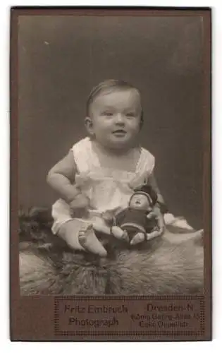 Fotografie Fritz Embruch, Dresden, niedliches Kleinkind mit ihrer Puppe auf dem Schoss