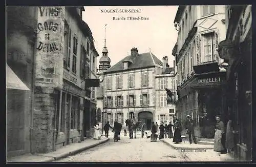 AK Nogent-sur-Seine, Rue de l`Hôtel-Dieu animée avec passants et commerces