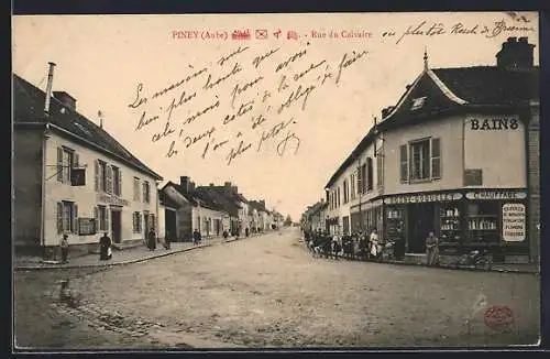 AK Piney, Rue du Calvaire animée avec boutiques et passants