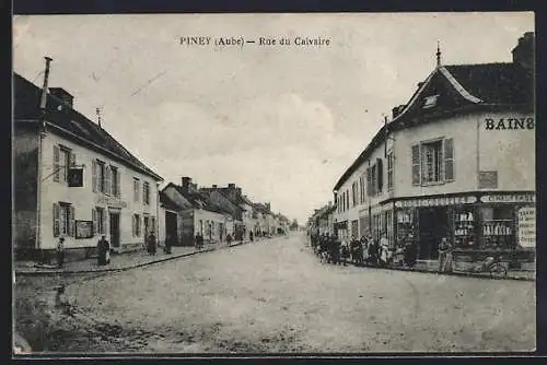AK Piney, Rue du Calvaire animée avec commerces et passants