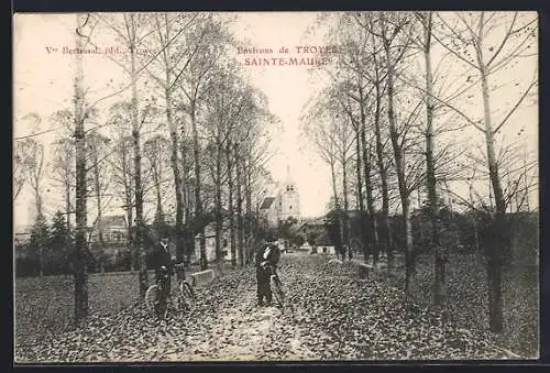AK Sainte-Maure, Allée bordée d`arbres avec cyclistes et vue sur l`église