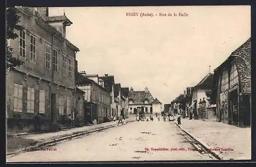 AK Piney, Rue de la Halle animée avec bâtiments historiques