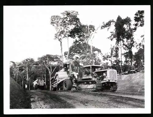 Fotografie Affaires Culturelles, Ansicht Douala / Kamerun, Raupenschlepper transportiert Baumaschine für den Strassenbau