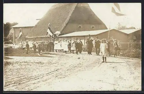 Foto-AK Kellinghusen, Strassenumzug mit deutschen Flaggen vor einem Reetdach-Gehöft, 1914