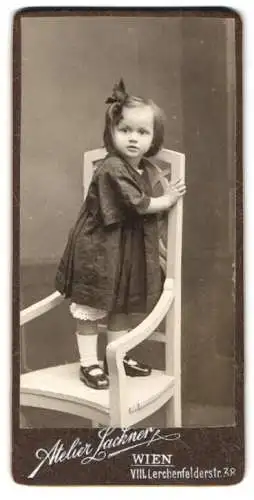 Fotografie Atelier Lackner, Wien, Lerchenfelderstr. 38, niedliches Mädchen auf Jugendstil Stuhl stehend