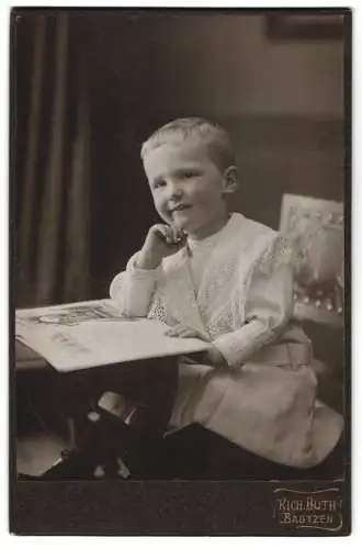 Fotografie Richard Huth, Bautzen, Wendischestrasse 13, Knabe in nachdenklicher Pose mit Bilderbuch