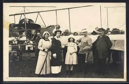 Foto-AK Damen und Herren posieren vor einem Flugzeug