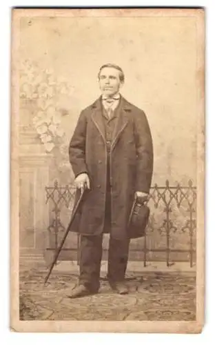 Fotografie W. Filser, Kaufbeuren, Stehender Mann mit Regenschirm