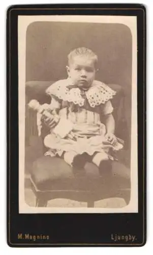 Fotografie M. Magnino, Ljungby, Kleinkind auf Stuhl mit Puppe