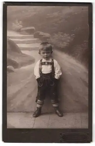 Fotografie Paul Hüttner, Münchberg, Knabe in Tracht vor Studiokulisse
