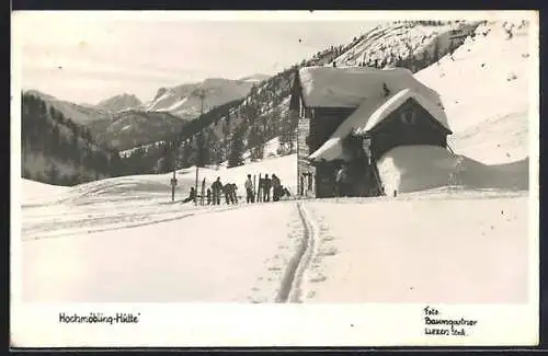 AK Hochmöbling-Hütte, Ansicht mit Gipfelpanorama und Skiläufern im Winter