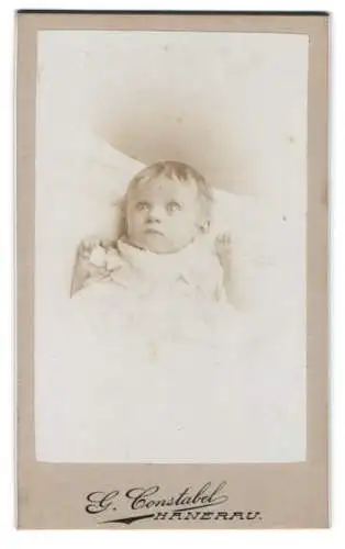 Fotografie G. Constabel, Hanerau, Liegendes Kleinkind in heller Kleidung
