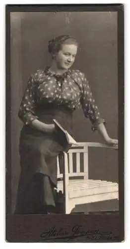 Fotografie Atelier Jensen, Kiel, Klinke 26, Frau mit Buch auf Armlehne eines Stuhls sitzend