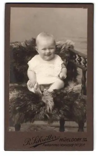 Fotografie R. Schrötter, Mühldorf, Katharinen-Vorstadt 98a, Lächelndes Baby auf Fell