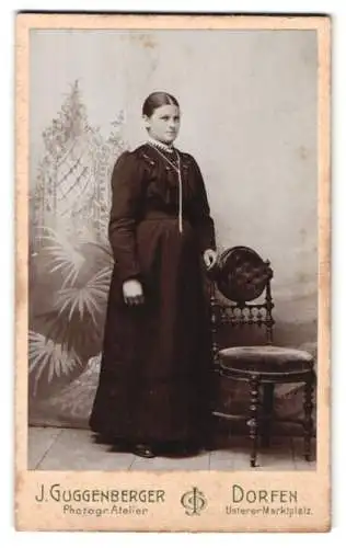 Fotografie J. Guggenberger, Dorfen, Unterer Marktplatz, Stehende Frau mit elegantem Stuhl