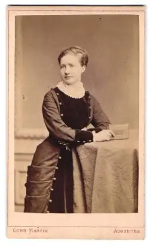 Fotografie Gebr. Martin, Augsburg, Bahnhofstrasse, Frau mit elegantem Kleid am Tisch