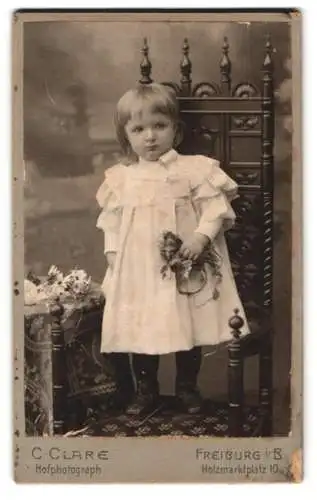 Fotografie C. Clare, Freiburg i. B., Holzmarktplatz 10, Porträt eines Kindes mit Blumenstrauss