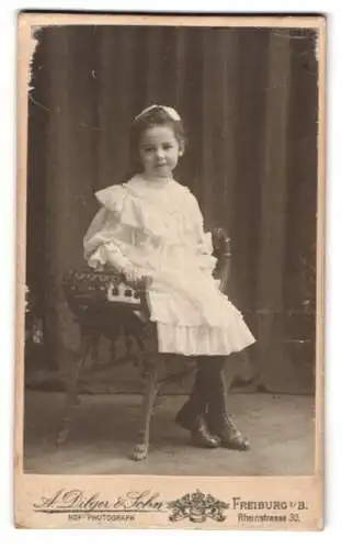 Fotografie A. Dilger & Sohn, Freiburg i. B., Rheinstrasse 30, Mädchen in weissem Kleid auf Stuhl
