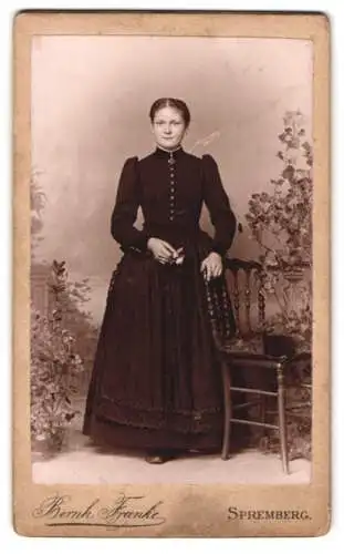 Fotografie Bernh. Franke, Spremberg, Stehende Dame mit Blumen in der Hand