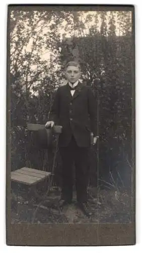Fotografie unbekannter Fotograf und Ort, Junge mit Hut und Buch im Garten