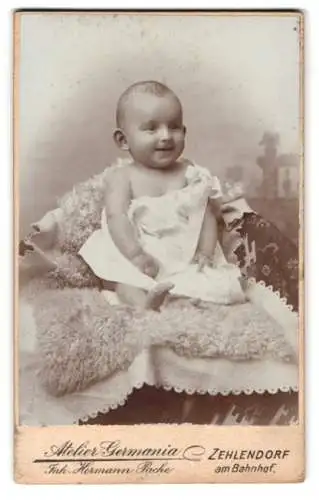 Fotografie Atelier Germania, Zehlendorf, am Bahnhof, Lächelndes Baby auf Decke