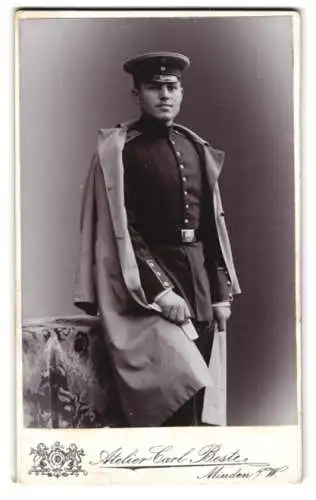 Fotografie Atelier Carl Beste, Minden /W., Bäckerstr. 13, Soldat in Uniform mit Mantel