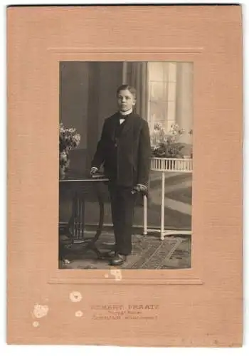 Fotografie Albert Fraatz, Darmstadt, Wilhelminenplatz 2, Junge im Anzug neben Tisch