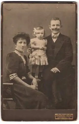 Fotografie Sandberg-Heese, Schwerin i. M., Königstrasse 29, Porträt einer Familie mit kleinem Kind
