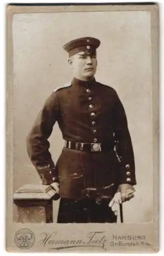 Fotografie Hermann Tietz, Hamburg, Gr. Burstah 12/14, Soldat in Uniform mit Schirmmütze und Bajonett vom Rgt. Nr. 76